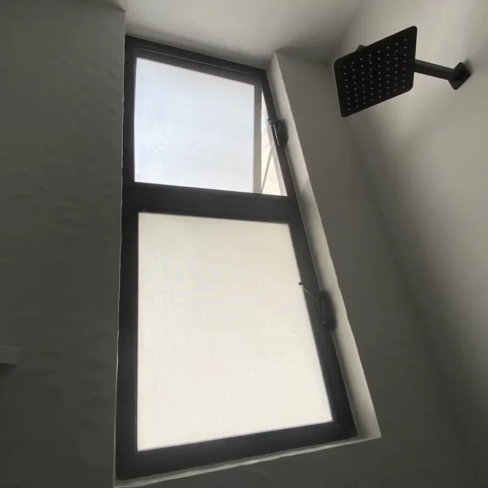 Ventana de baño con vidrio esmerilado, uno de los vidrios para baño más usados