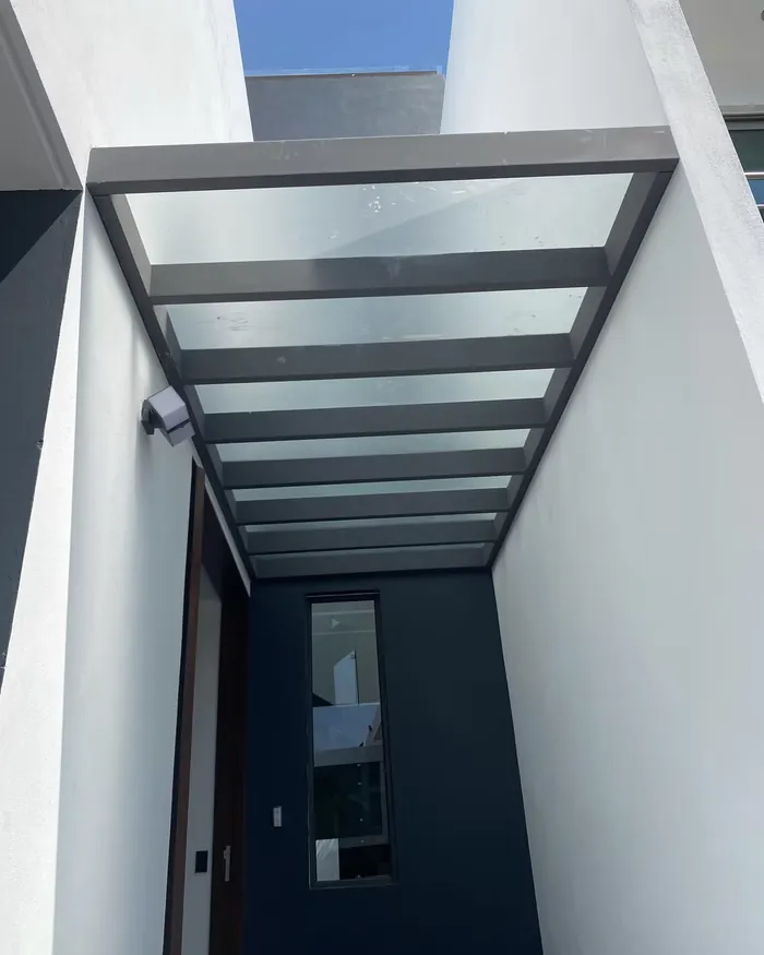 Estructura de aluminio arquitectónico con techo de cristal en un pasillo
