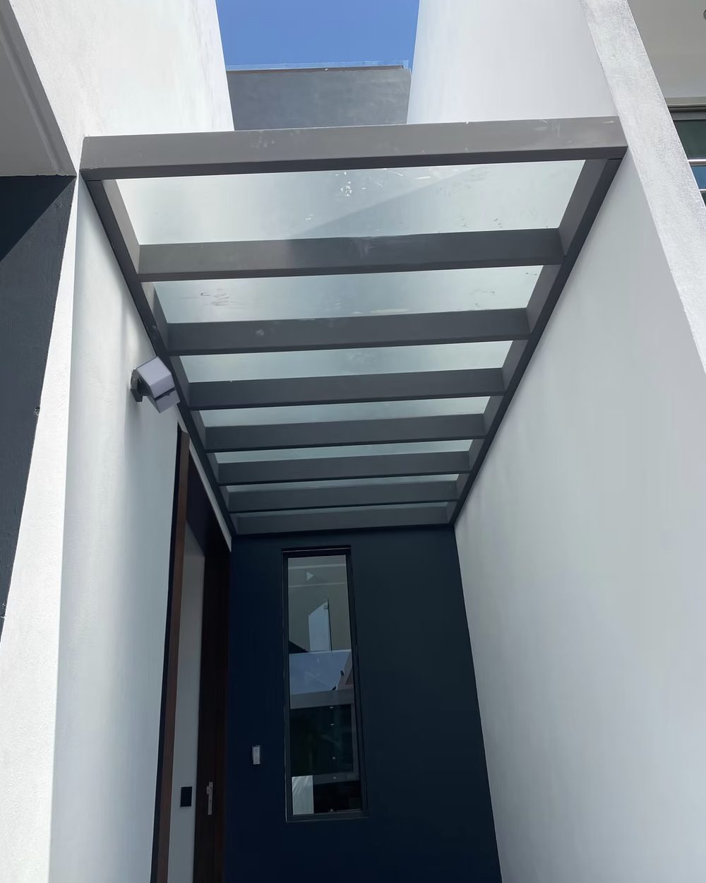 Techo de cristal con estructura de vidrio y aluminio en una entrada